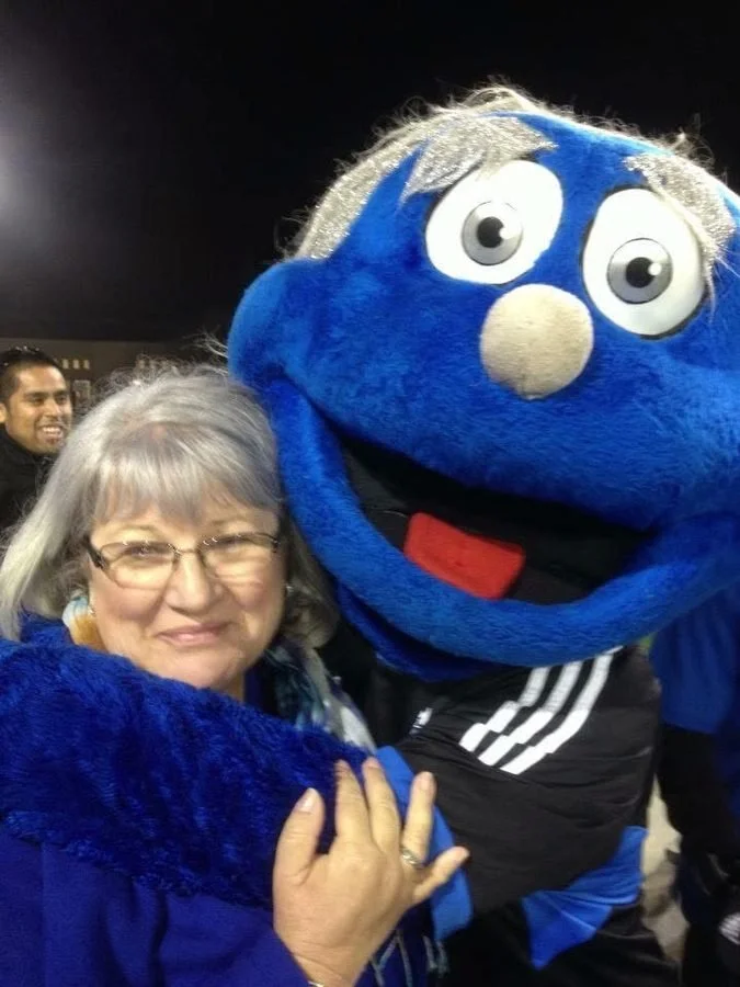 Mike's mom with Q, the San Jose Earthquakes mascot, at night at Santa Clara University