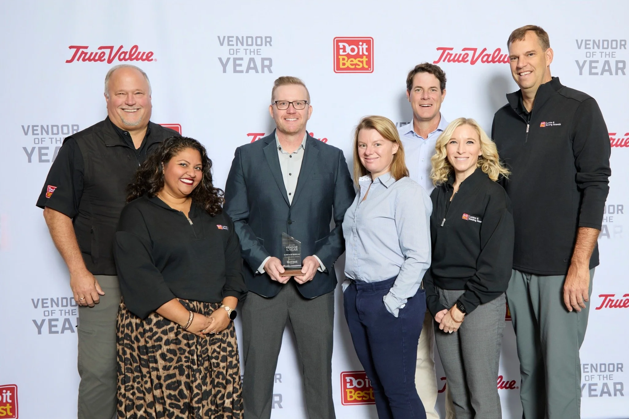 Group photo with a Surface Shields Vendor of the Year award and Do it Best and True Value logos