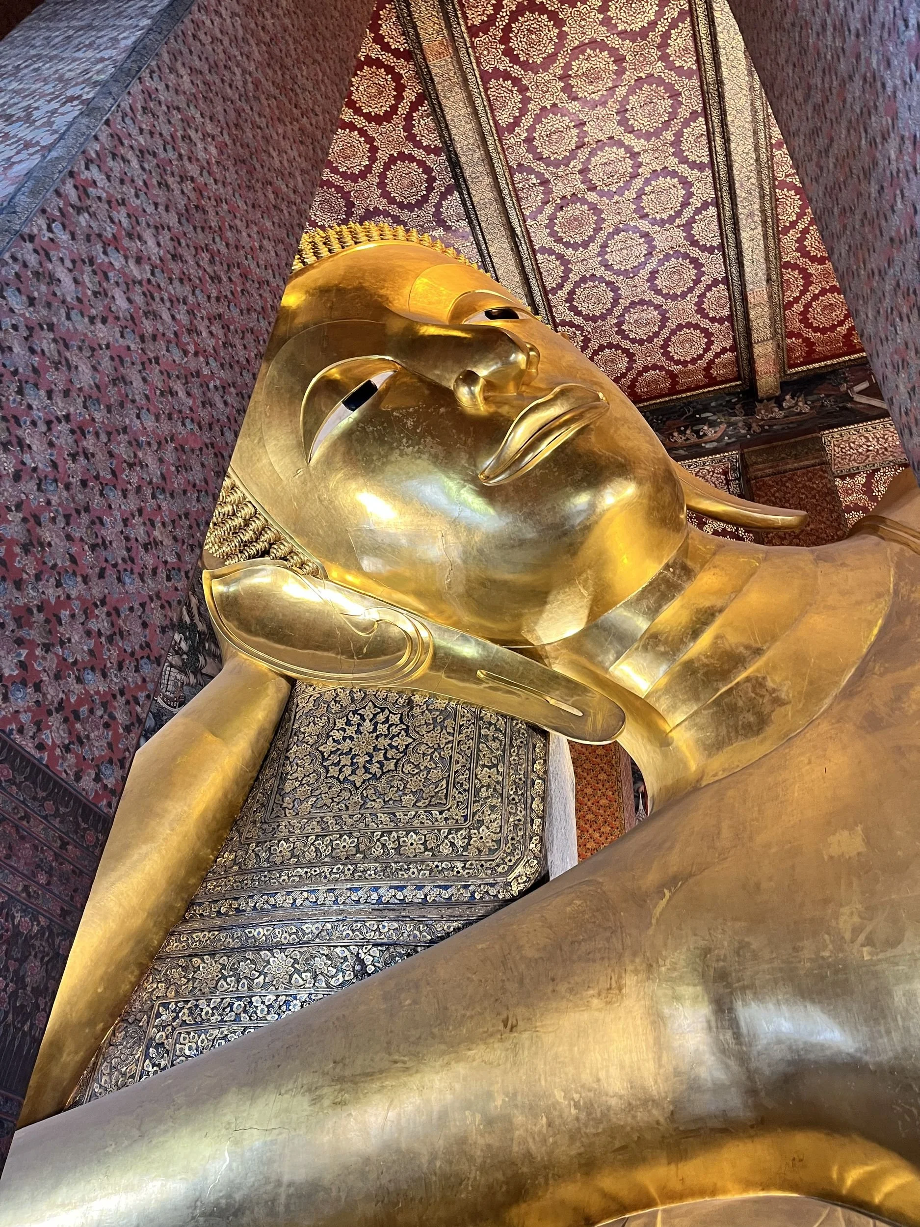 A golden reclining Buddha inside a Thai temple