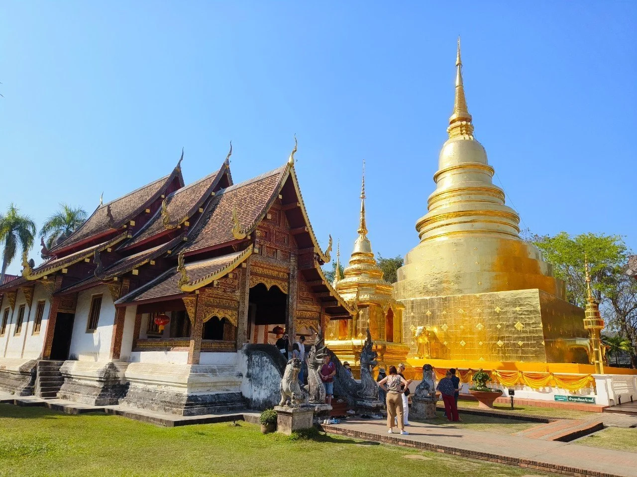 A golden chedi beside a traditional Thai temple