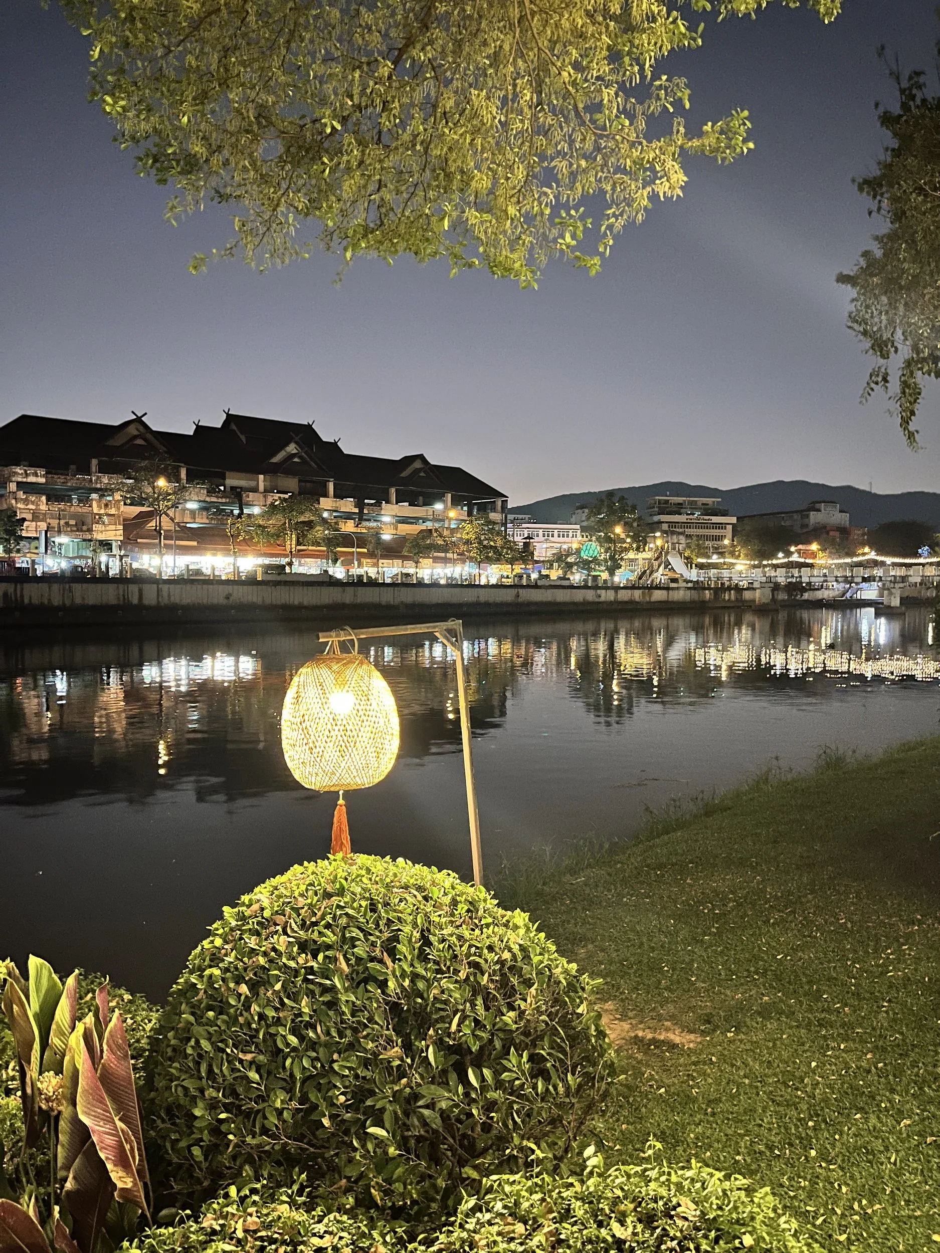 A lantern glowing beside the river at night