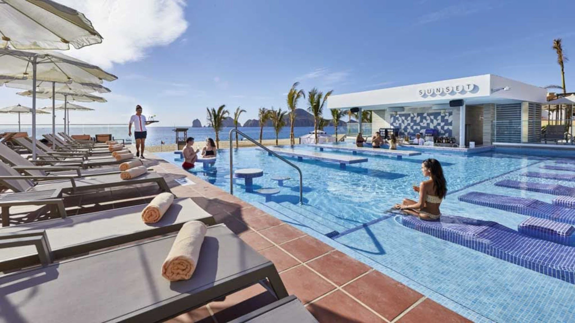 Pool with loungers steps from the beach