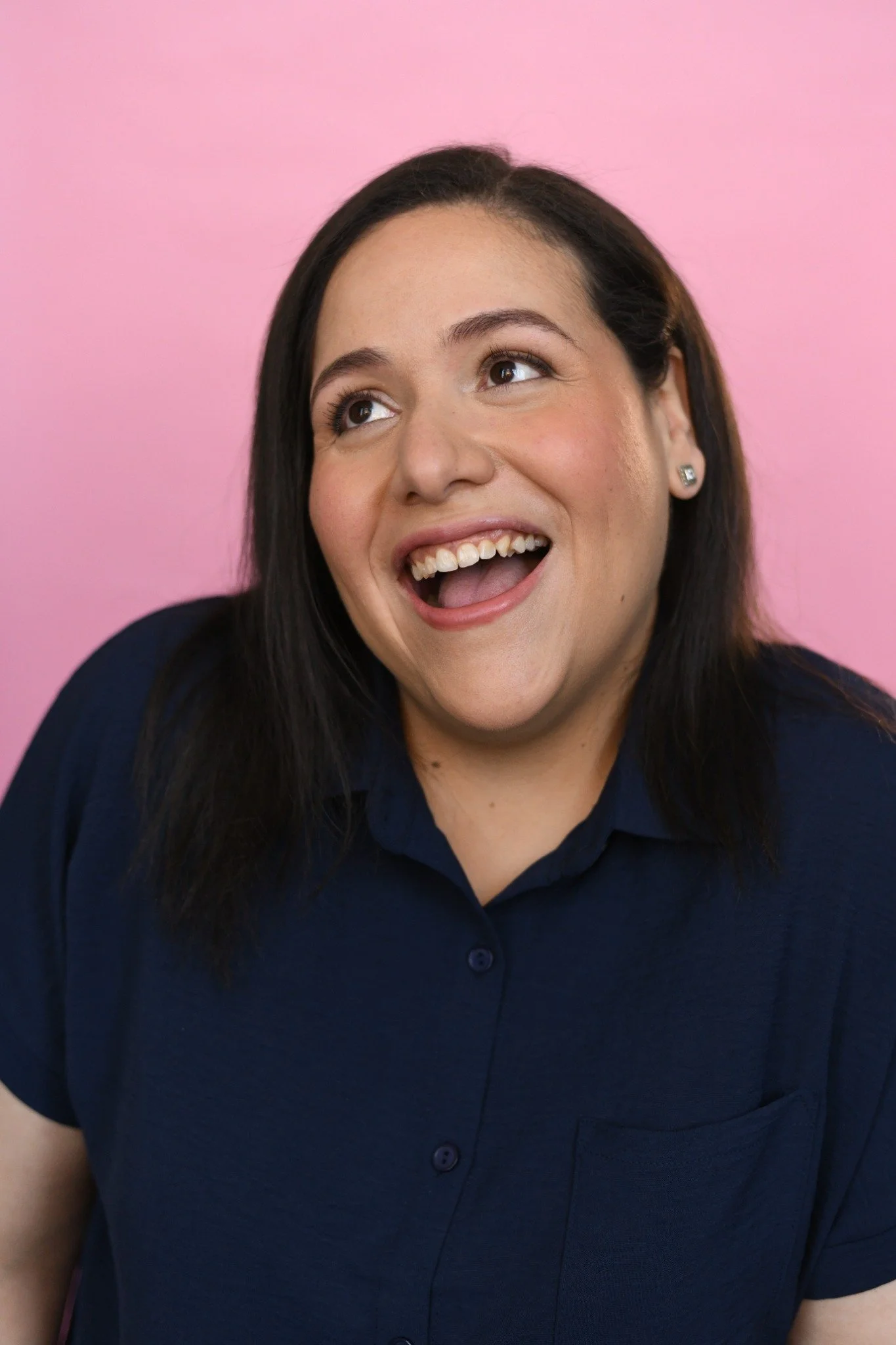 Villy looking up with a playful smile during her headshot shoot.