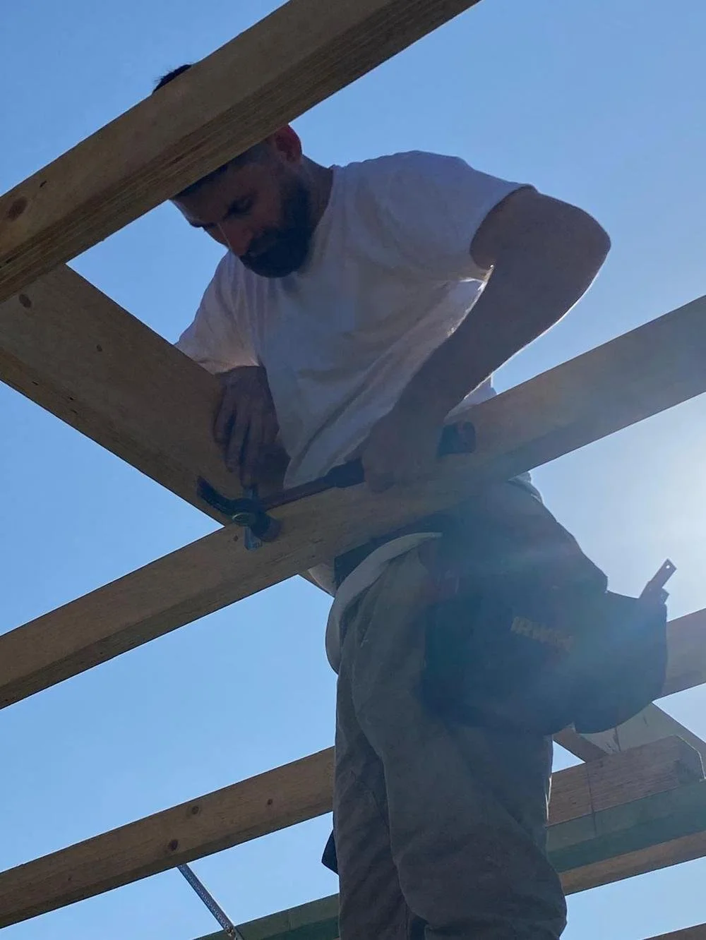 Ilia fixing a pergola beam on site