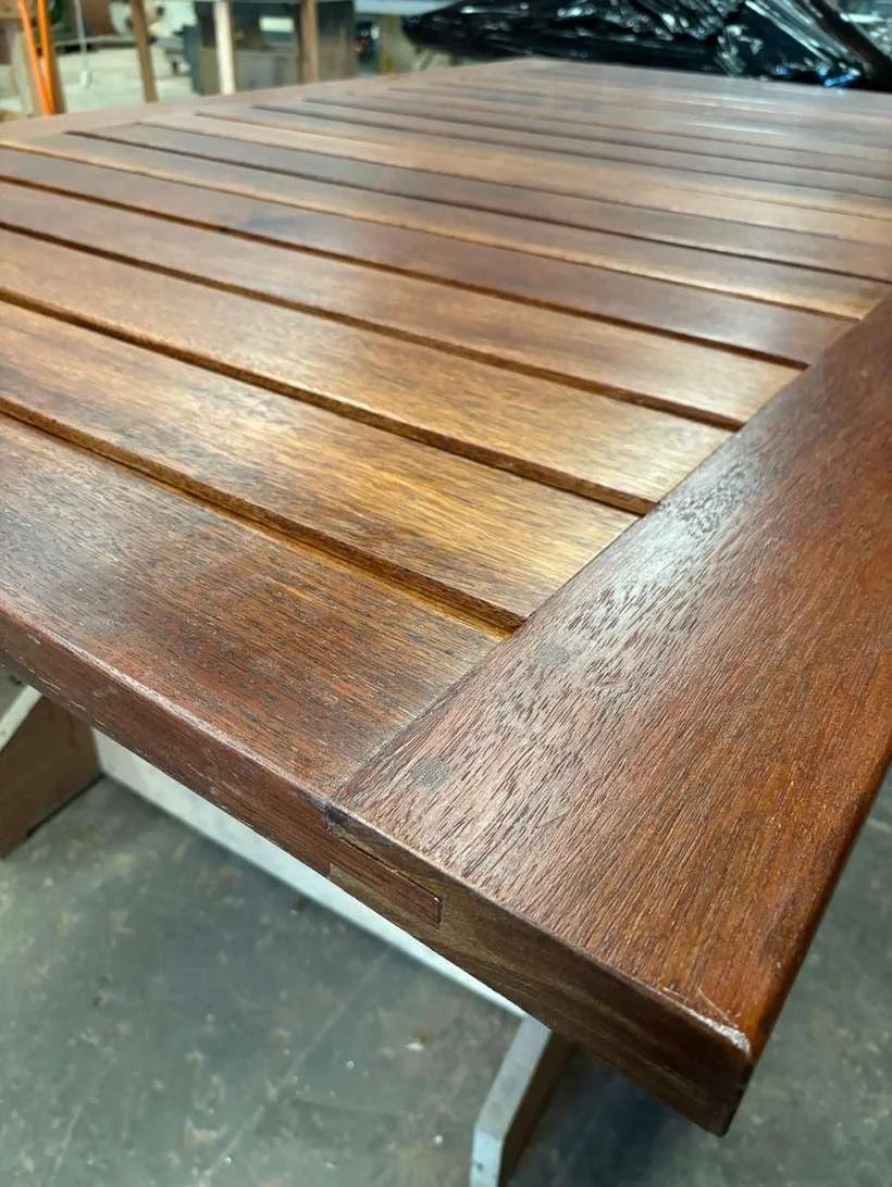 Close-up of a slatted hardwood table top with a breadboard end