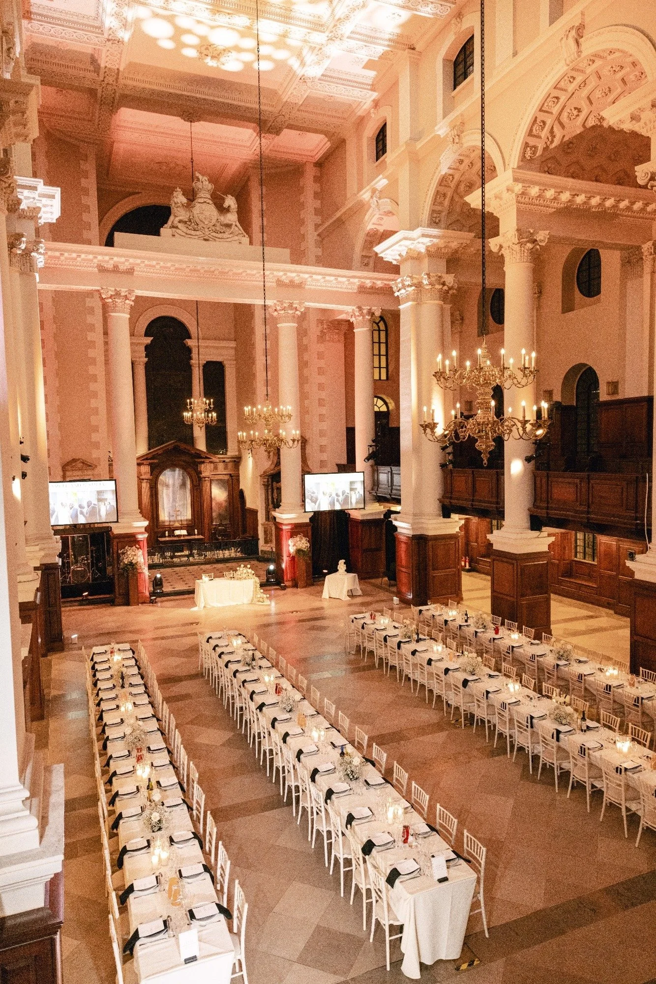 The Nave set for wedding dining with long tables dressed in white cloths