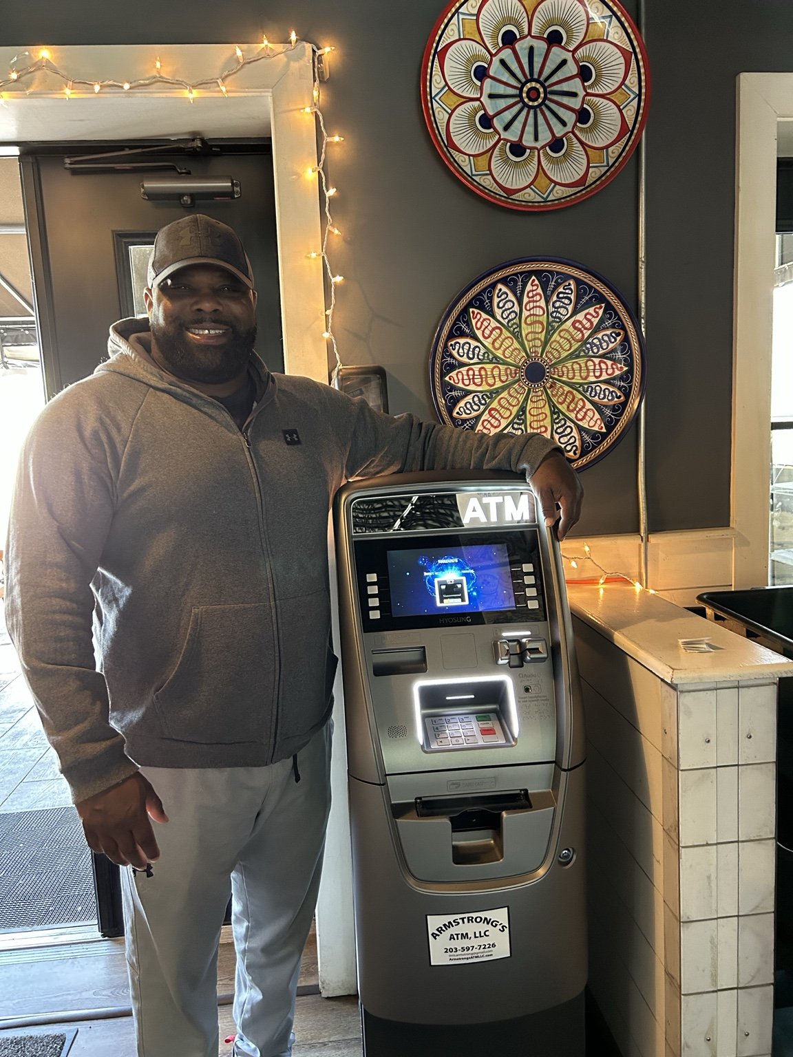 An Armstrong’s company representative beside a branded ATM