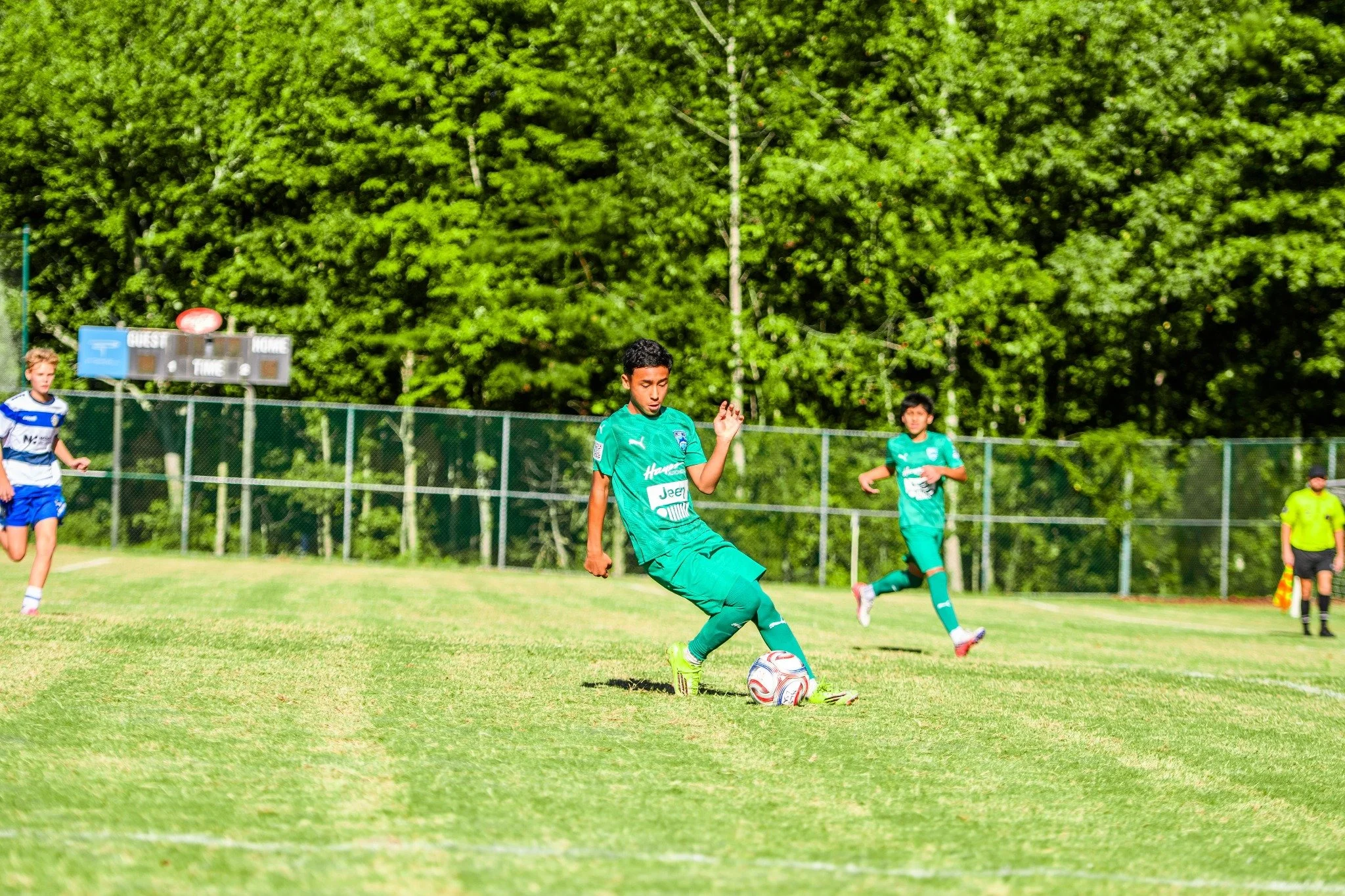 Jugador de LSA con uniforme verde controlando el balón en la cancha