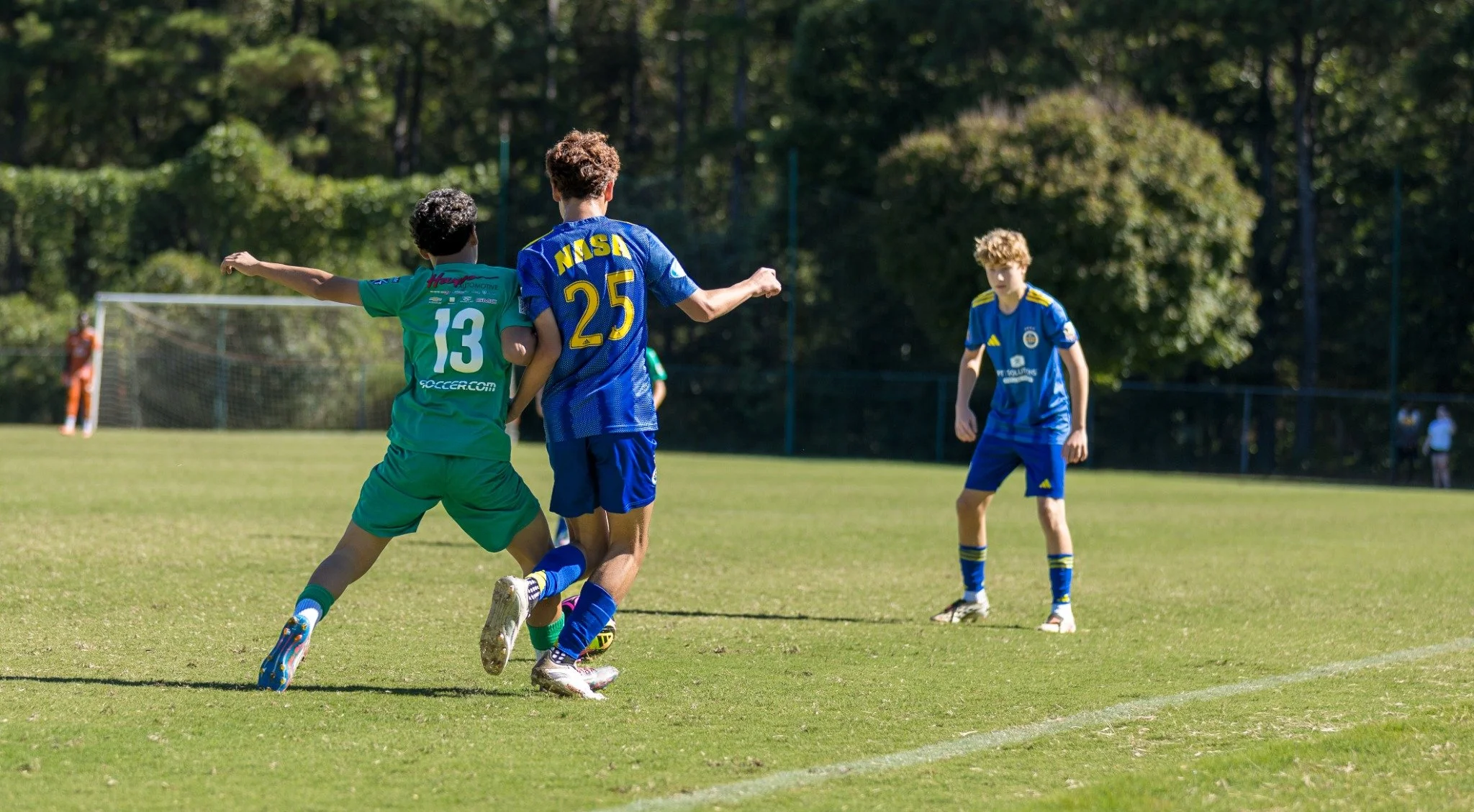 Jugador de LSA con uniforme verde disputando el balón durante un partido