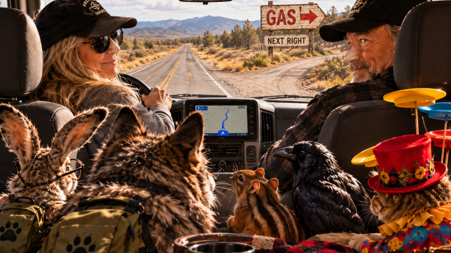 Inside the van: Jo drives, Max rides beside her, and the crew sits in back as a GAS sign appears ahead.