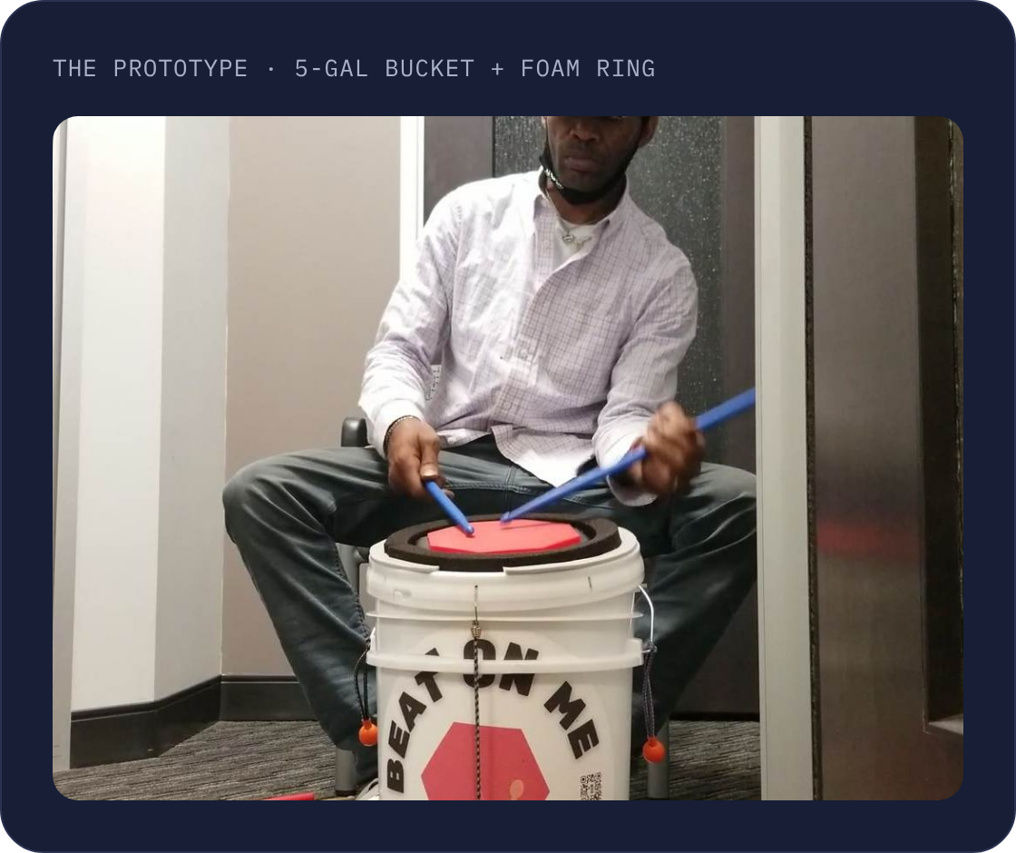 A drummer playing a BOM bucket drum, the classroom prototype