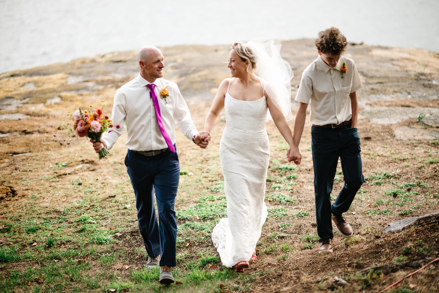 Hailey, Kyle and her son walking hand in hand through the meadow