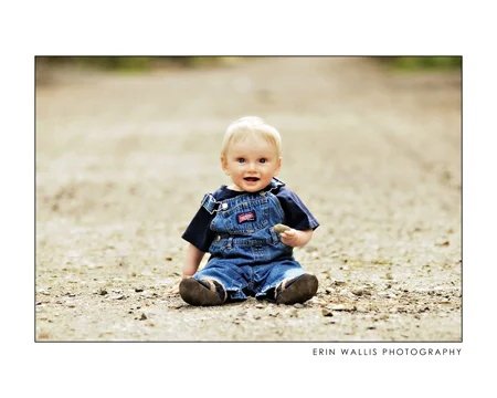 baby in road baby sitting on a dirt road