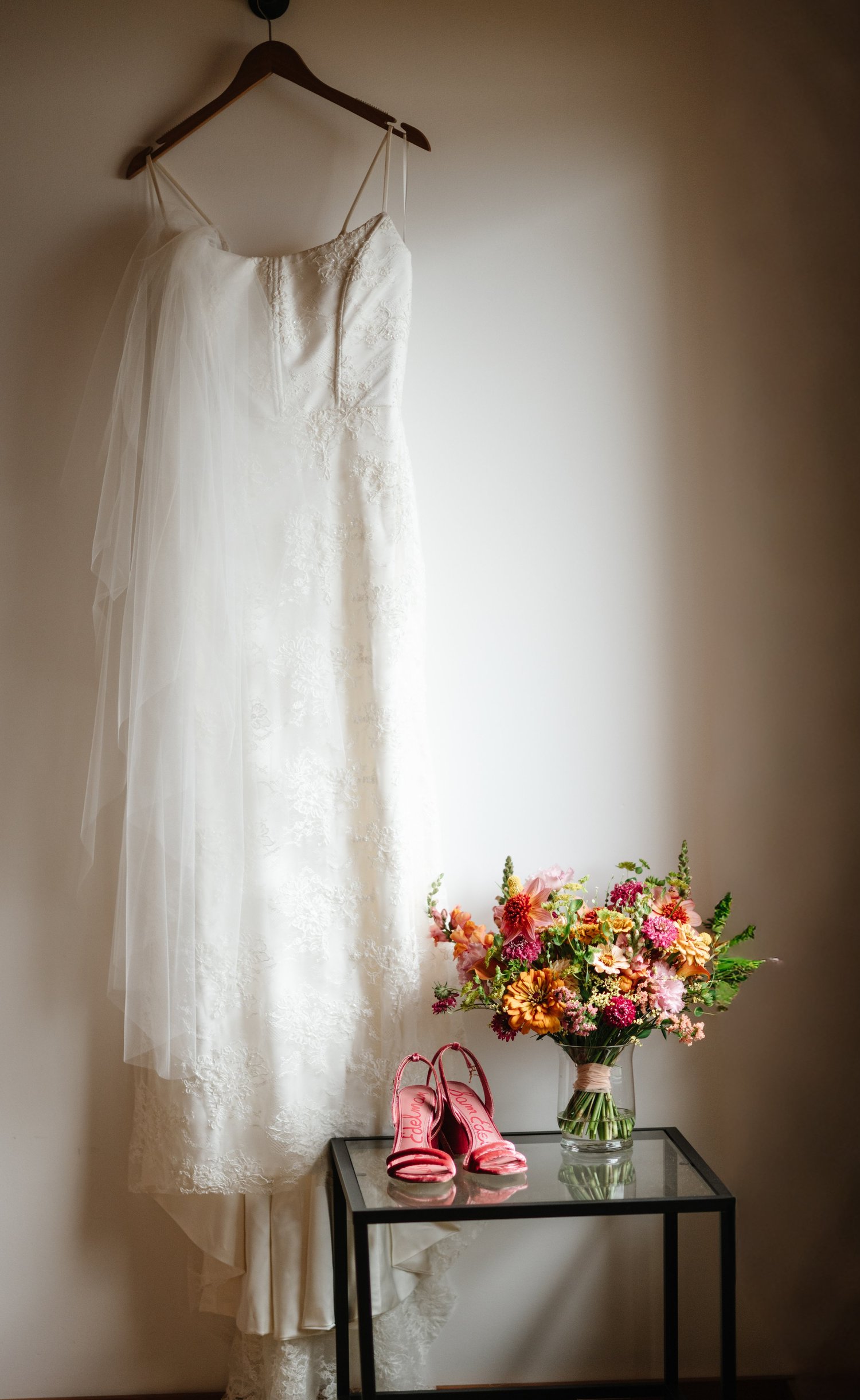 Hailey’s wedding dress hanging in the window light