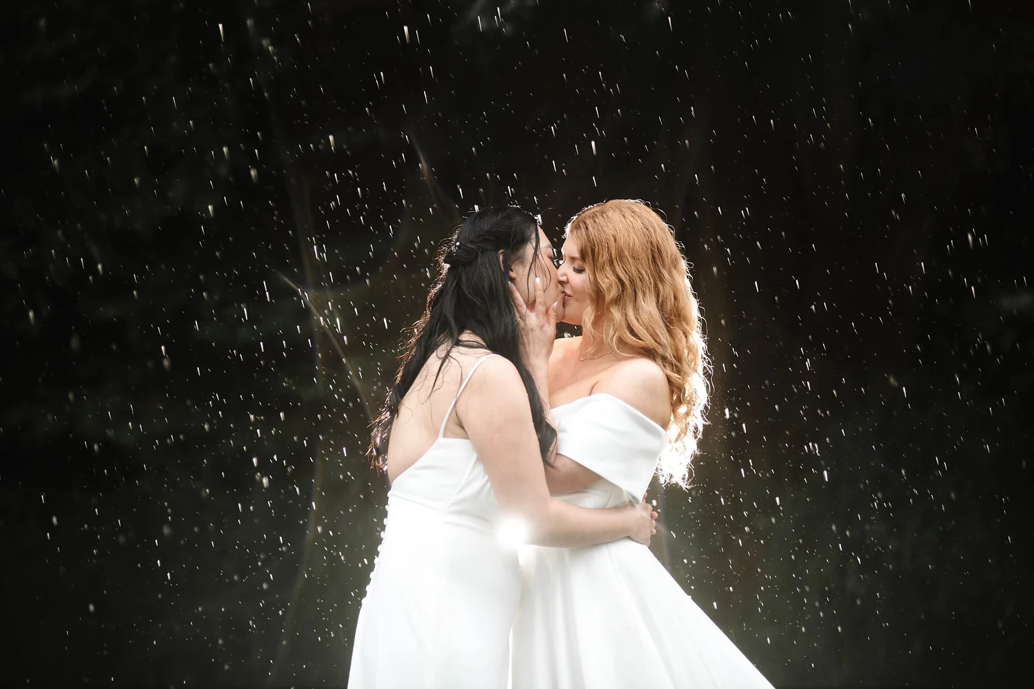 Emilie and Sunny embracing in the rain at night on their wedding day