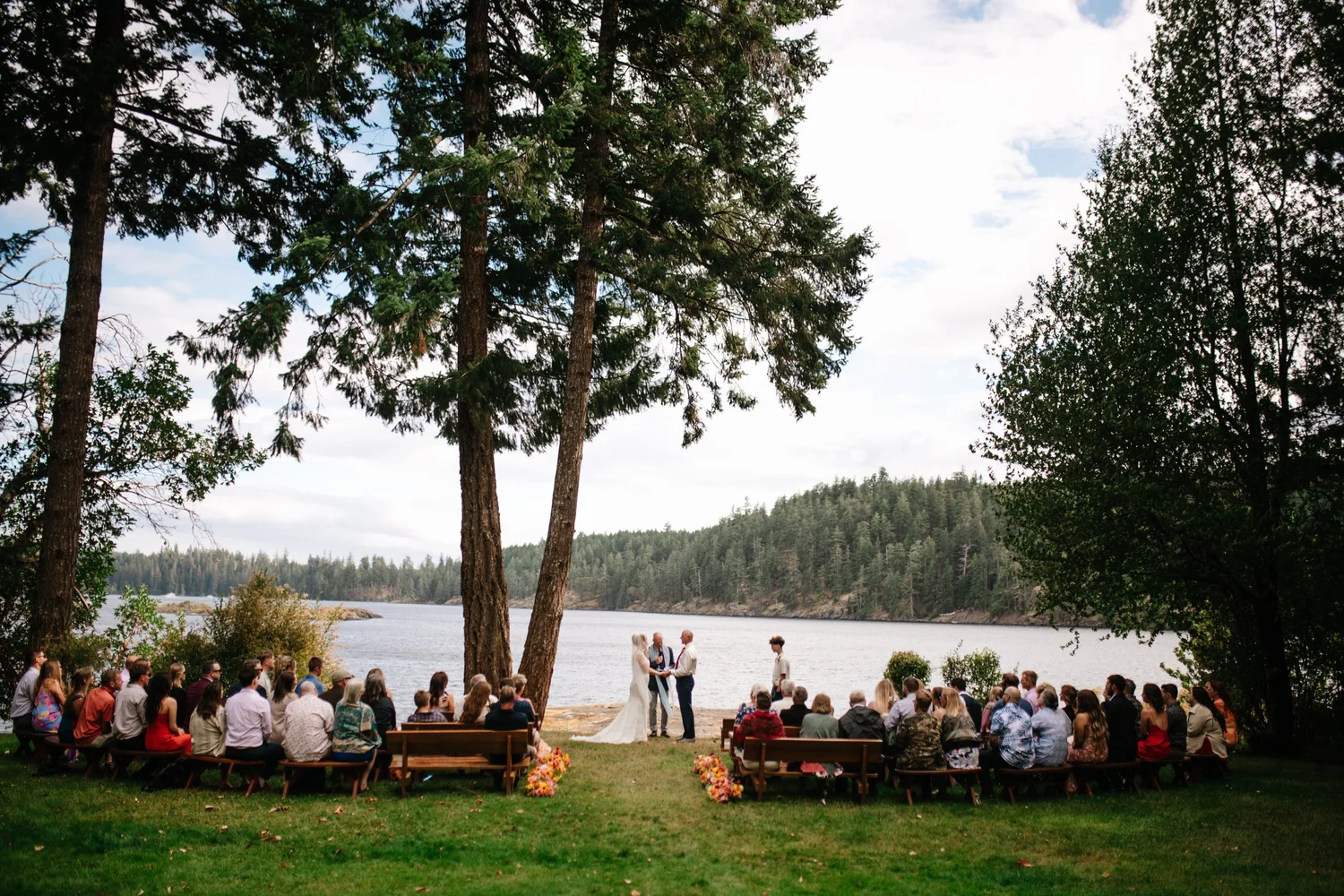 Guests gathered on the lawn above the water