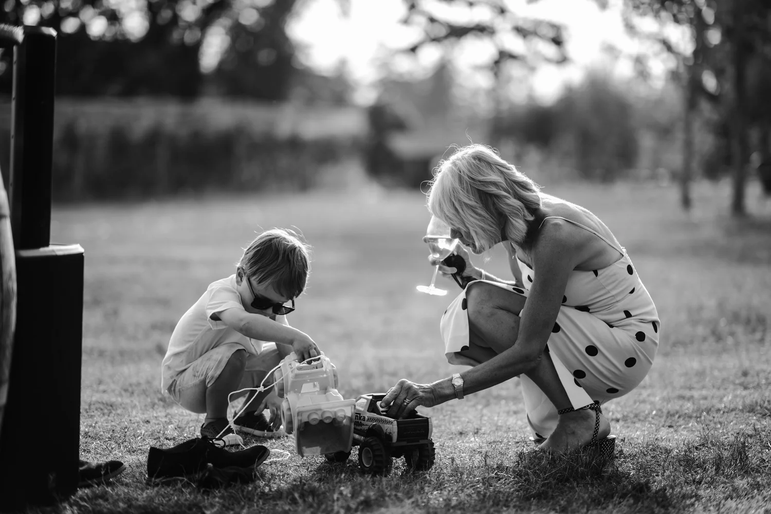 A little one and a guest playing on the lawn, in black and white