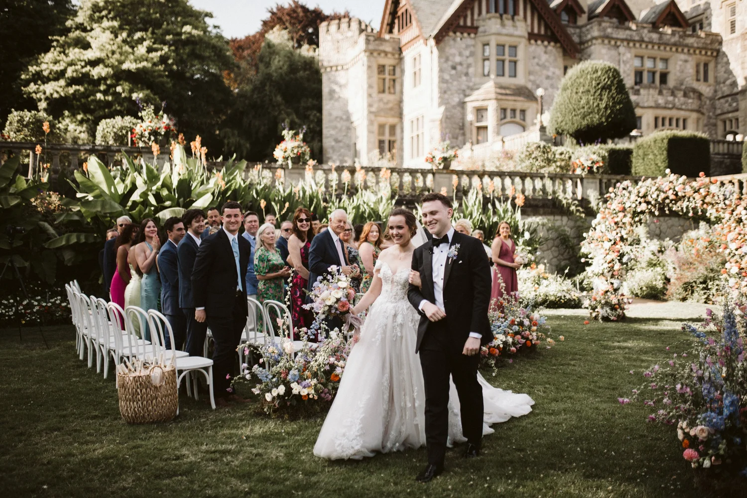 The couple walking back up the aisle in front of Hatley Castle