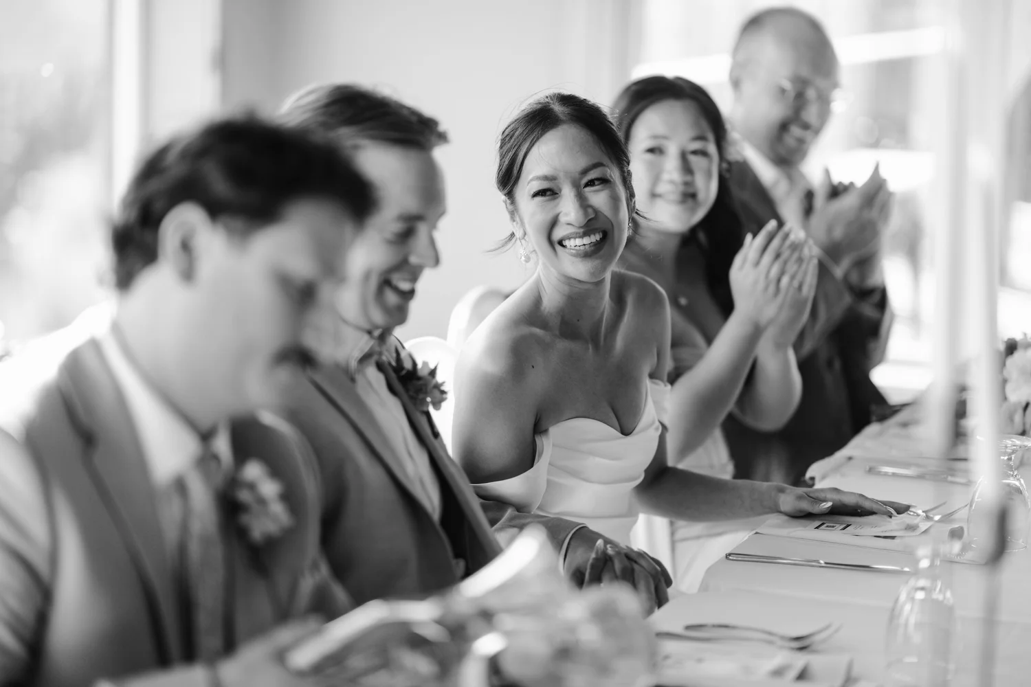Rea laughing at the head table during the toasts, in black and white