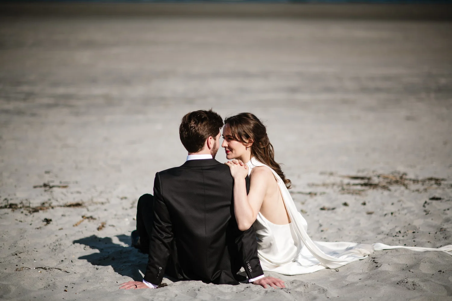 Dana and Cole sitting together in the sand