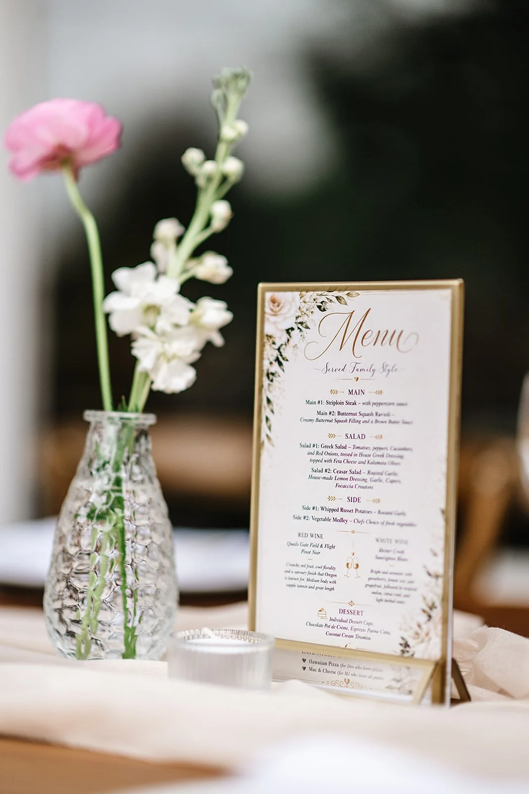 A handwritten letter and flowers at a place setting