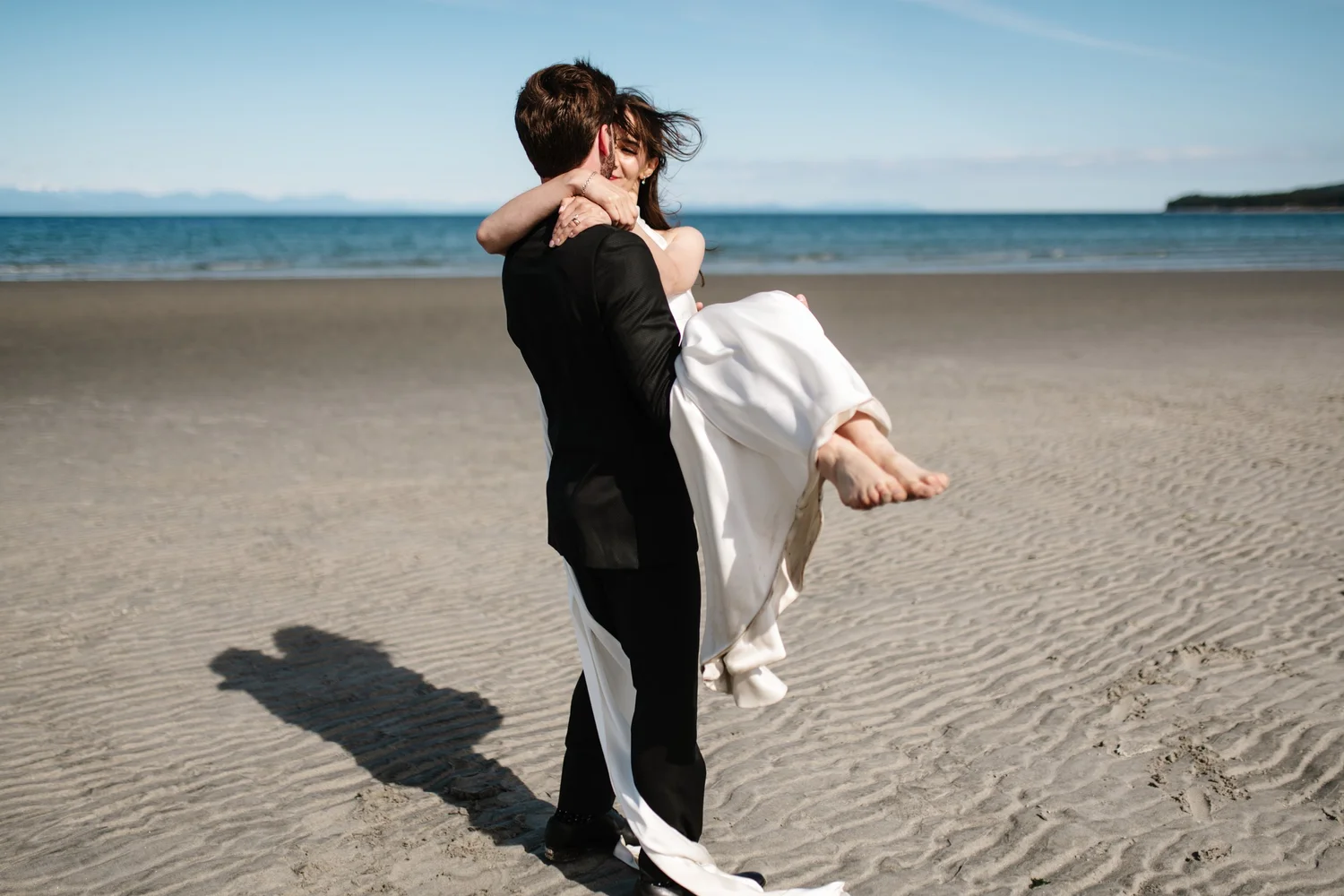 Cole carrying Dana across the sand