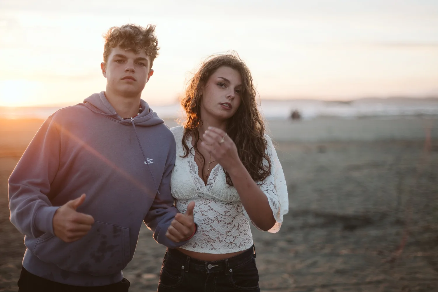 A brother and sister together on the beach at golden hour