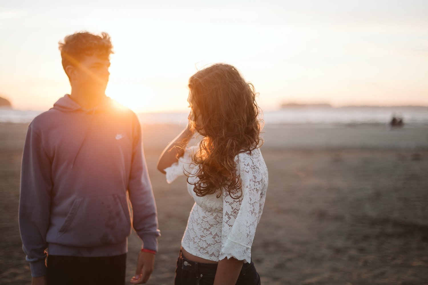 A brother and sister backlit by the setting sun on a Tofino beach