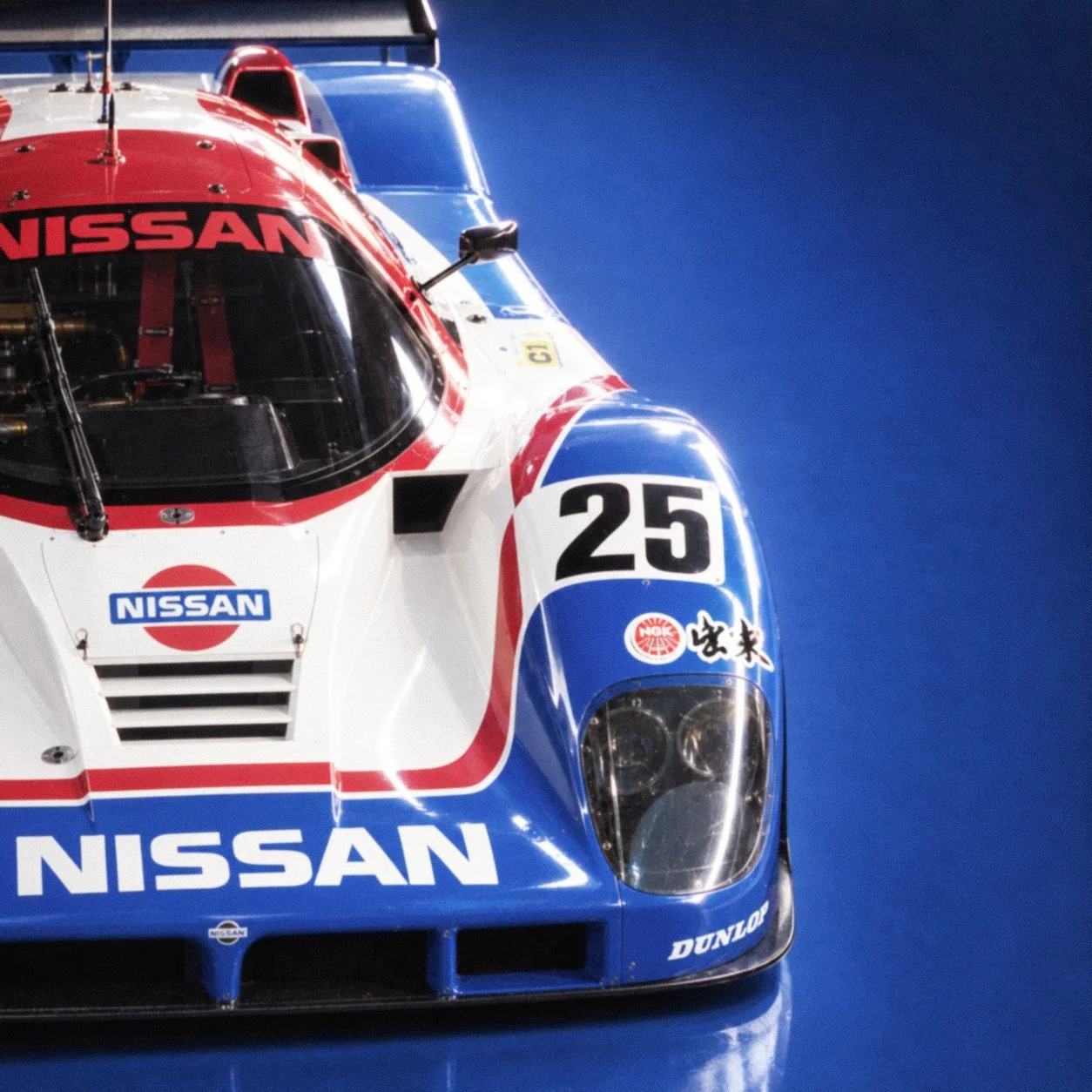 The nose of the car head on, with NISSAN and 25 on the bodywork.
