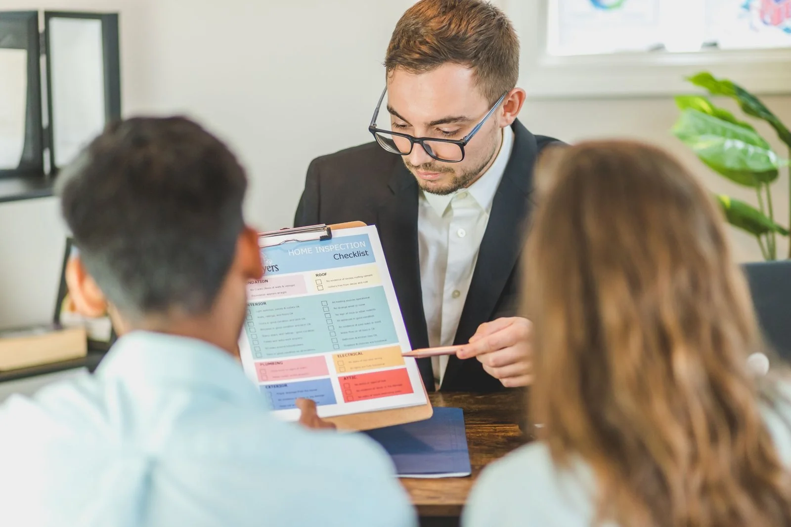 Real estate professional explaining a document to two people