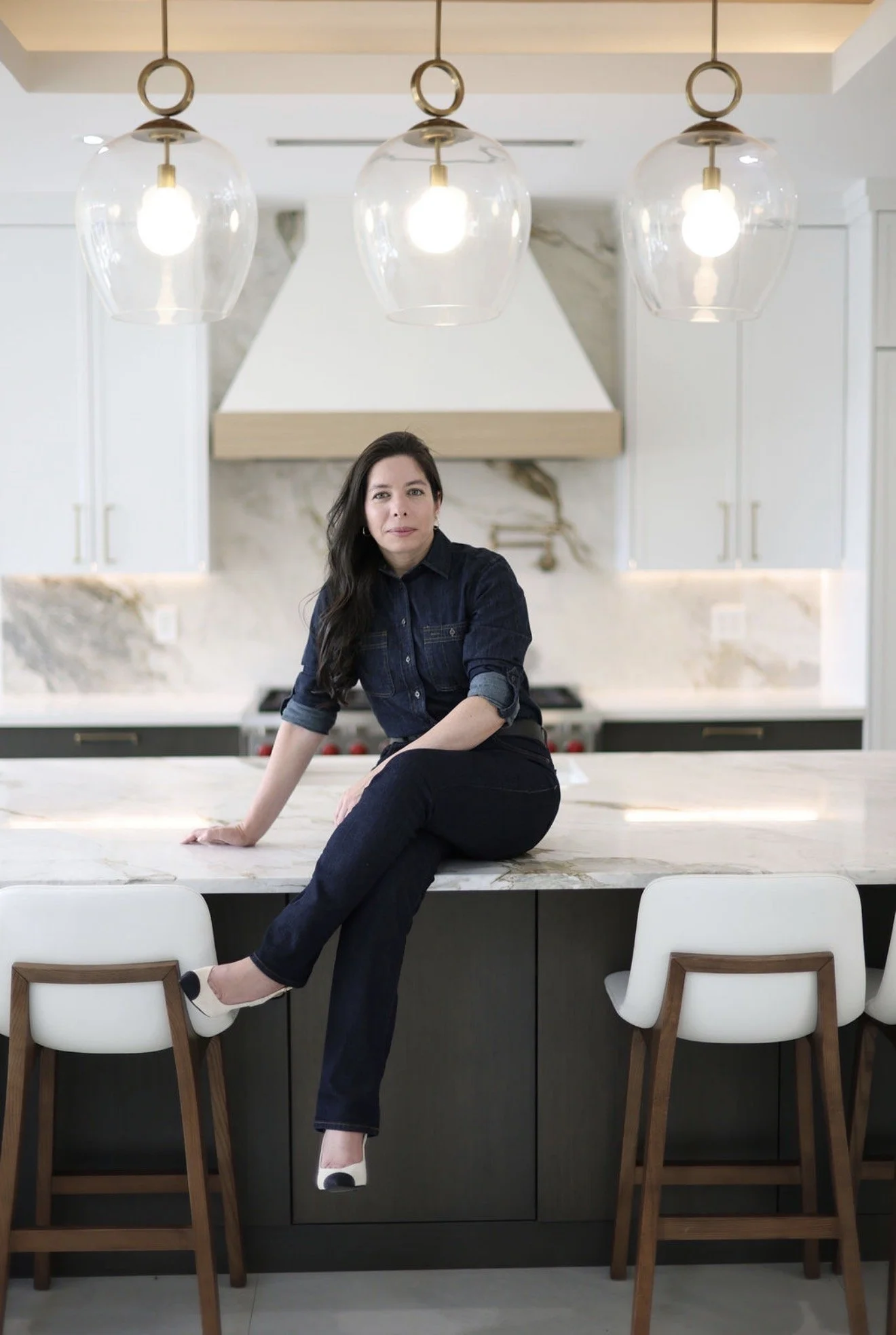 Vânia Aquino seated in a bright contemporary kitchen