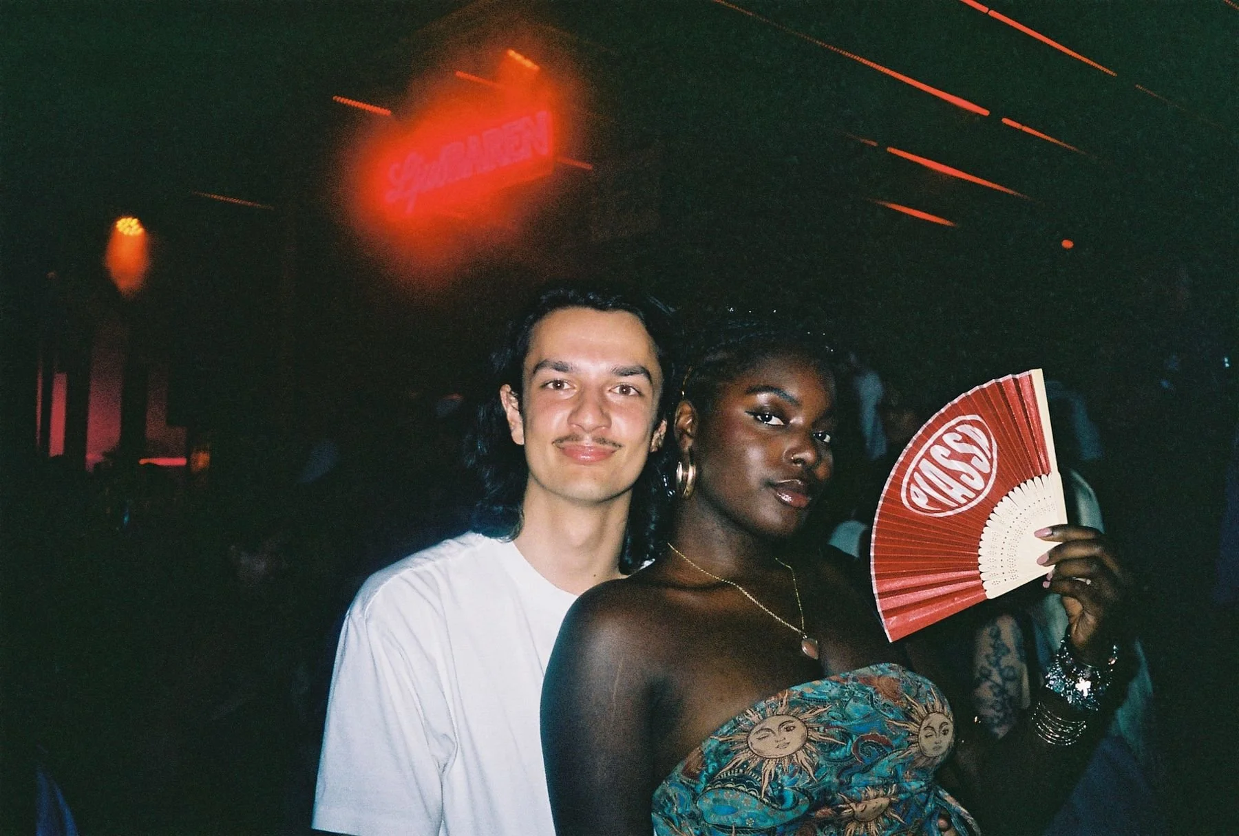 Two guests at Piassa, one holding a red Piassa fan