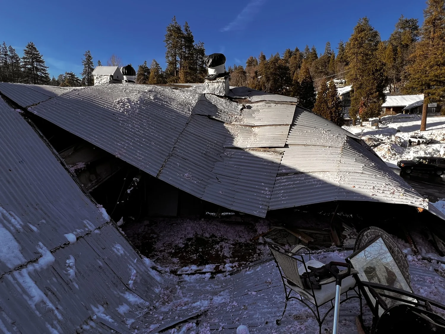The collapsed roof of the building under heavy snow