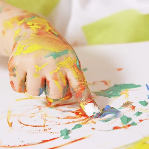 A small paint-covered hand finger painting