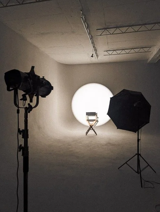 A photo studio with lights and a backdrop
