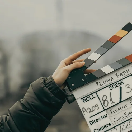 A hand holding a film clapperboard