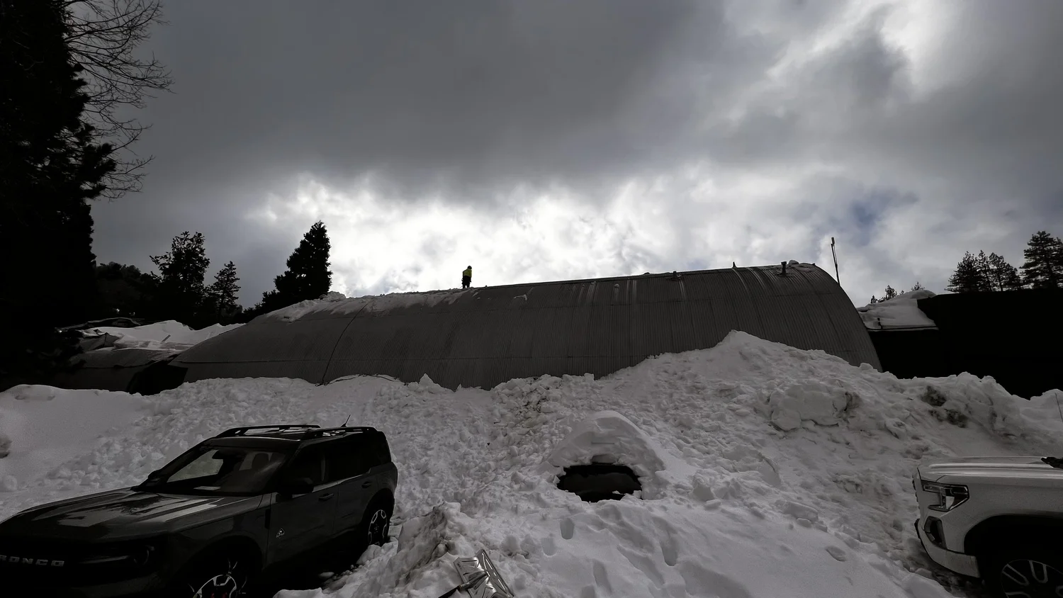 The building buried in snow under a stormy sky