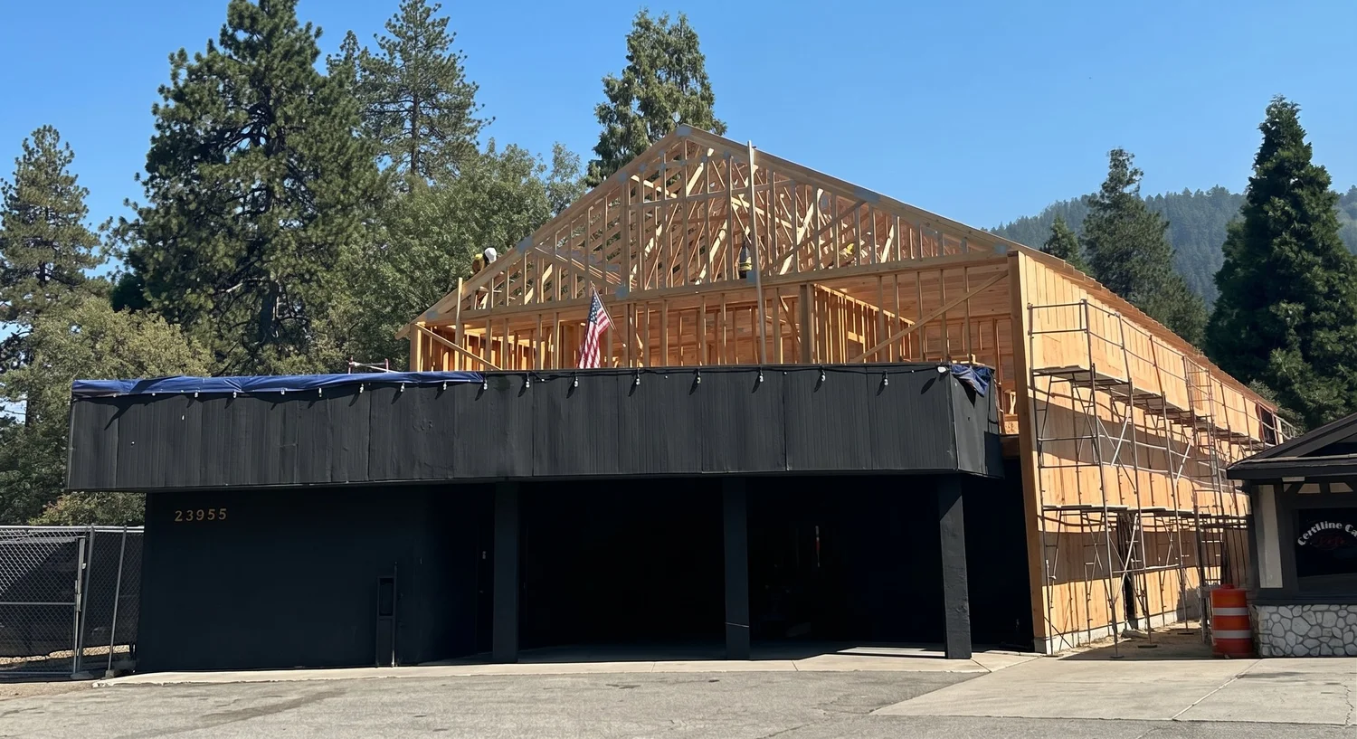 The new roof framing rising behind the dark front of the building