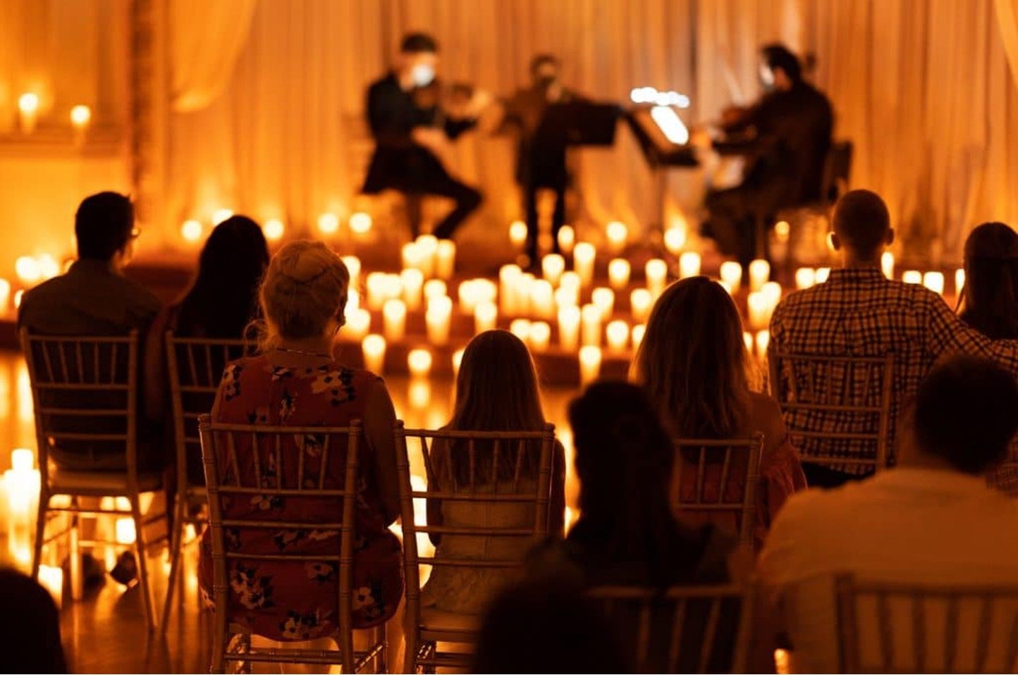 An audience watching a candlelit string performance
