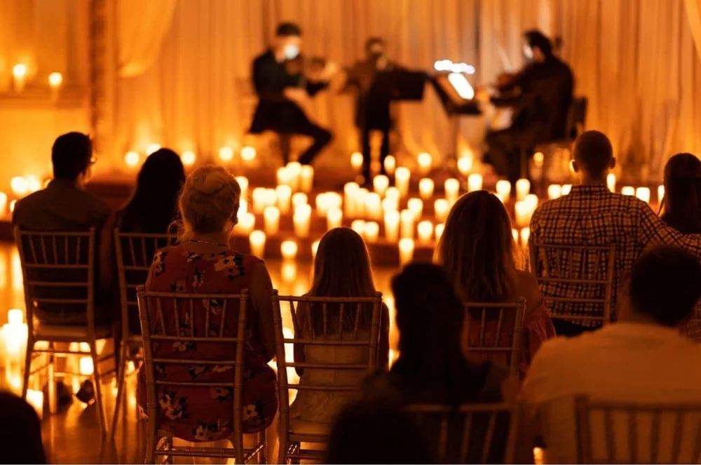 A string quartet playing among candles