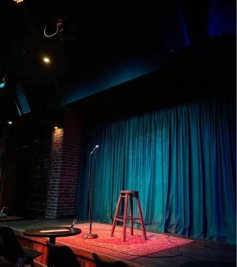 A comedy stage with a stool and mic