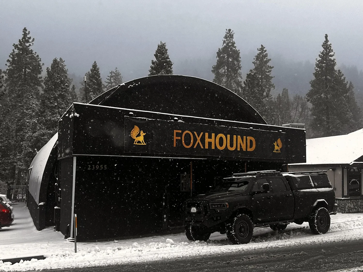 The building in the snow, with the Foxhound sign and a truck out front