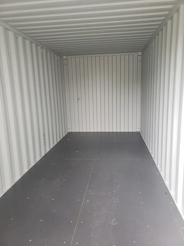 Clean container interior with white walls and a dark floor