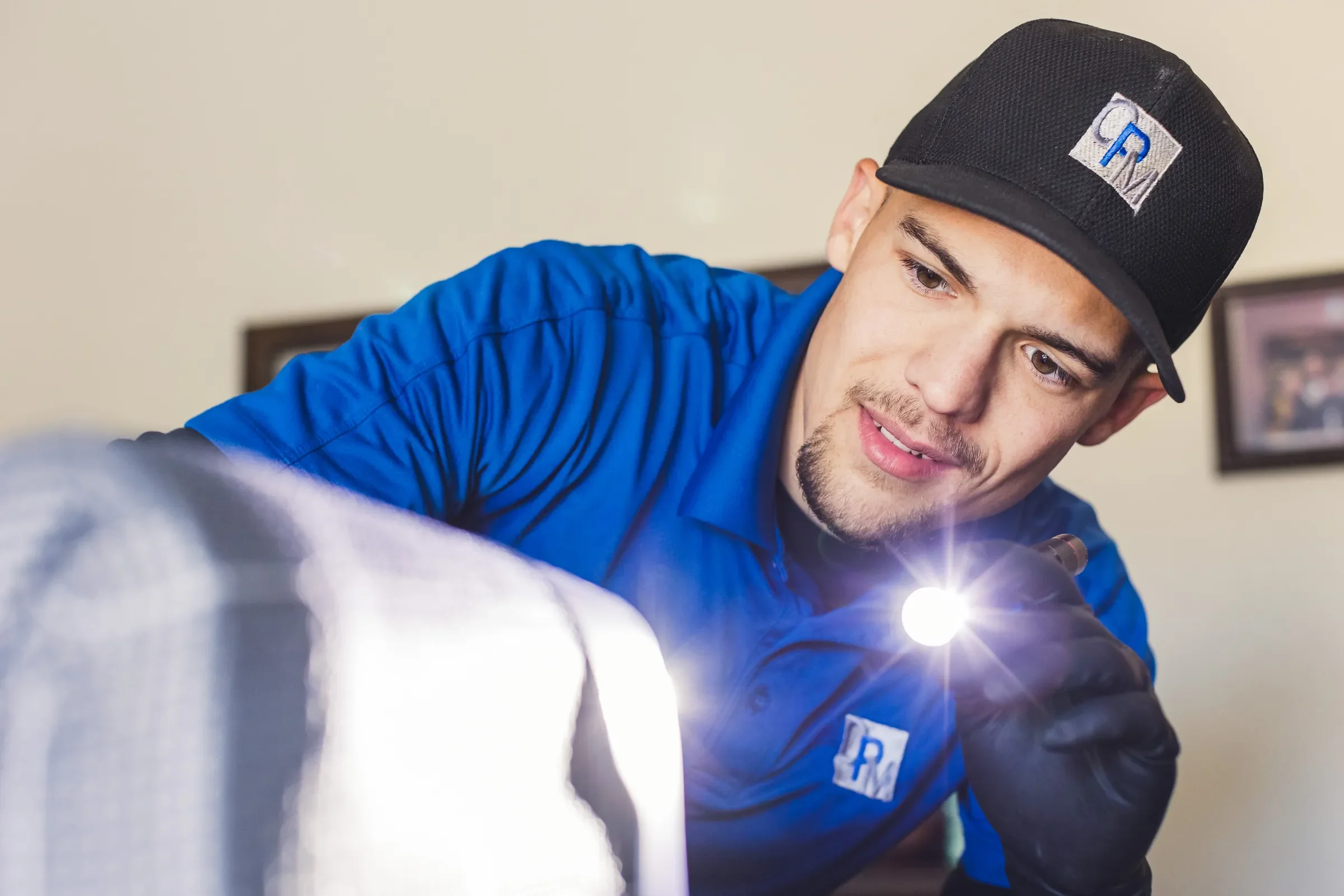 Bed bug inspection of a mattress seam with a flashlight in a Phoenix bedroom