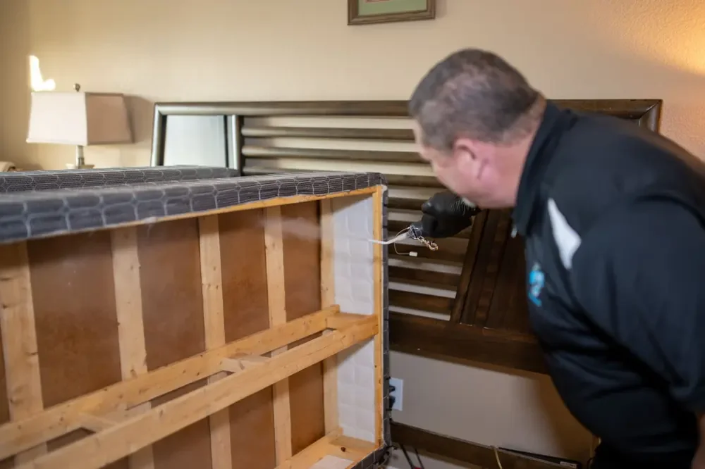 Bed Bugs Arizona treating a bed frame by hand