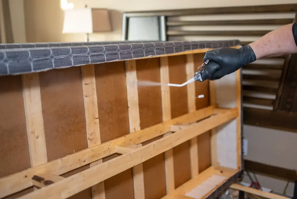 Bed Bugs Arizona treating a bed frame by hand