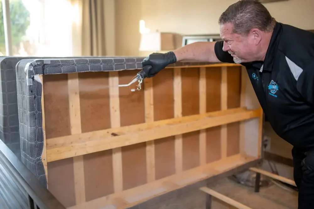 Bed Bugs Arizona treating a bed frame by hand