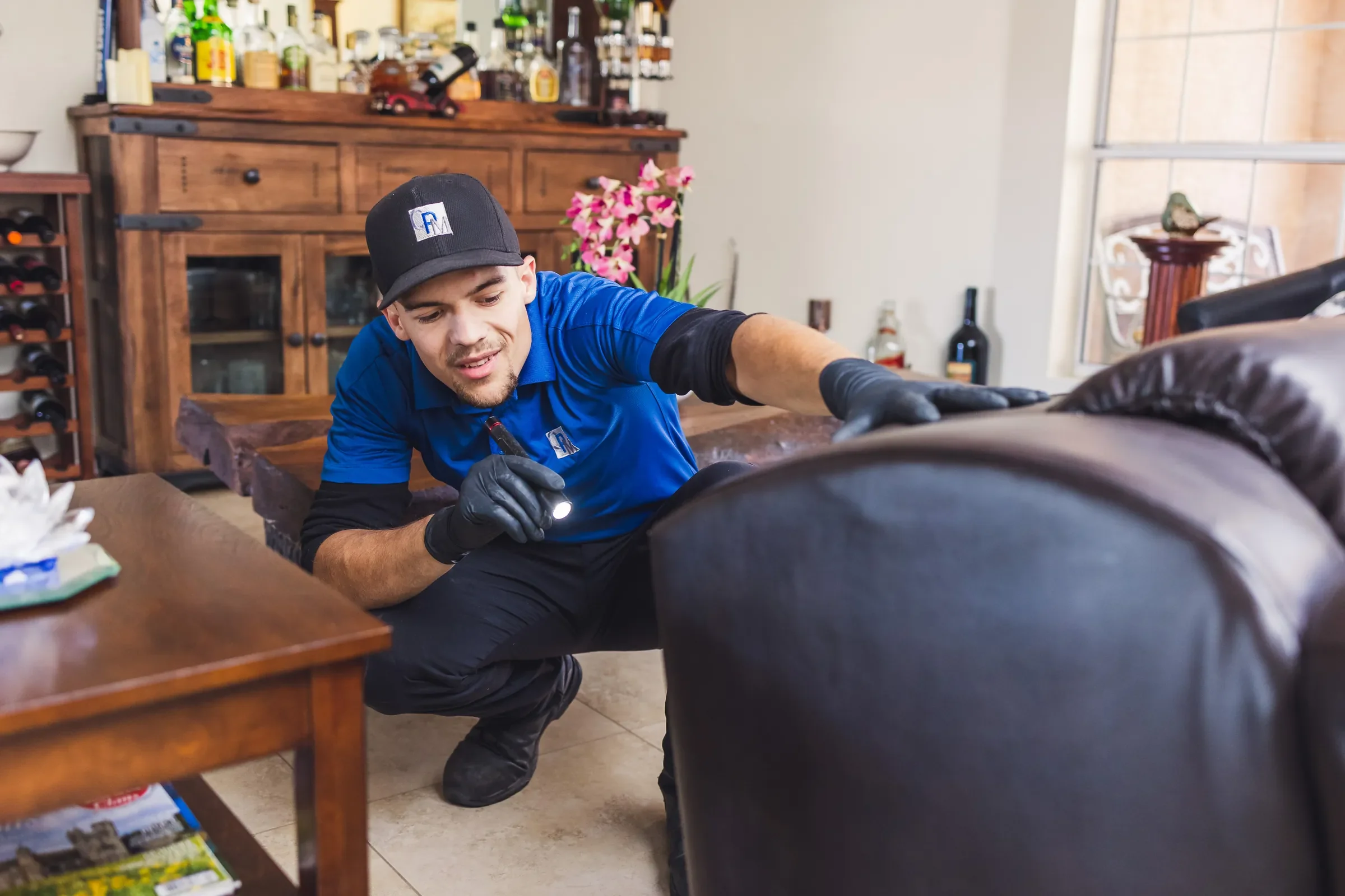 Bed Bugs Arizona inspecting a leather sofa for bed bugs