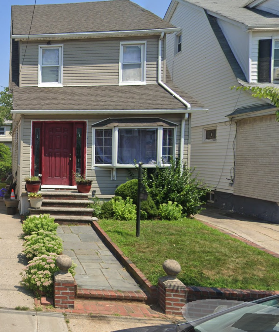 106th Avenue property in Queens Village, a residential home with a red front door and landscaped front yard
