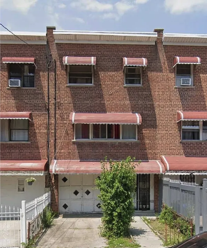 Barnes Avenue property in the Bronx, a brick residential building with red awnings and a driveway